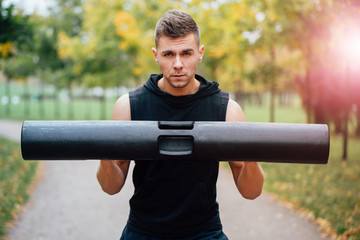 Male fitness doing exercise lunge with vipr, morning workout in the park. - obrazy, fototapety, plakaty