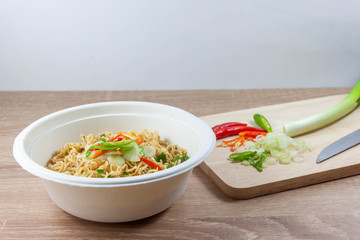 Instant noodles in bowls on wood table