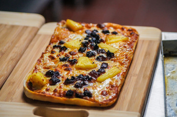 Mushroom pizza with mushroom cheese and tomato, on a wooden board.