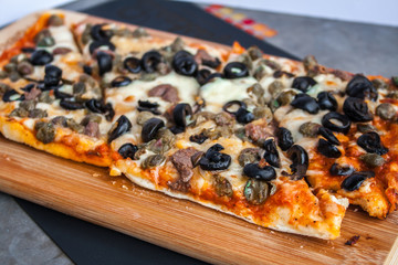 Mushroom pizza with mushroom cheese and tomato, on a wooden board.