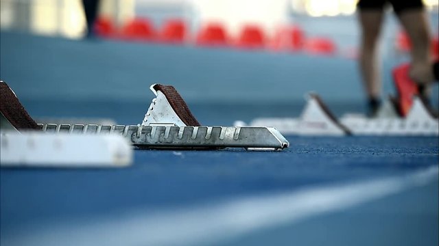 Man with leg prosthetics at the sprint start line in track and field competition