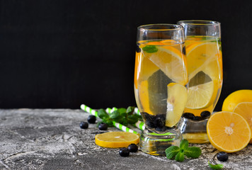 Traditional summer drink with lemon, blueberry and mint on a concrete background