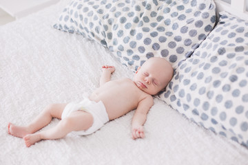 Portrait of newborn baby lying on parents bed.