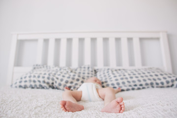 Fototapeta na wymiar Portrait of newborn baby lying on parents bed.