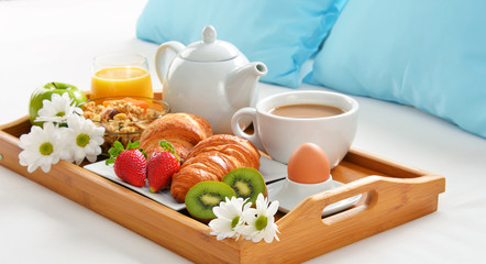 Breakfast tray in bed in hotel room