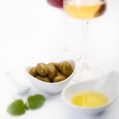 White wine, cheese and olives on white background