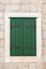 Closed green shuttered weathered wooden window