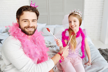 Smiling positive father giving lollipop to his daughter