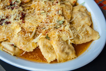 raviolis with onion and white sauce and cheese