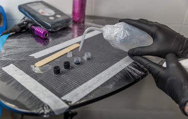 A tattoo artist woman stuffs a few small ink cartridges