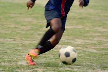 Boy is going to kick soccer ball.