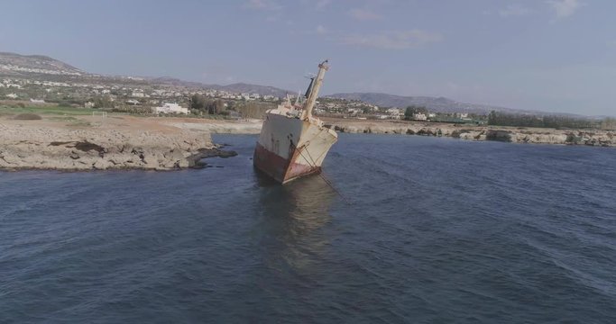 Aerial epic 4k shot of a big, old, broken, rusty boat near the coast of Peyia, Cyprus. Ship graveyard. Famous landmark in the Mediterranean sea.