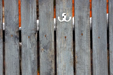 Деревянный забор с белой вешалкой