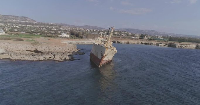 Aerial epic 4k shot of a big, old, broken, rusty boat near the coast of Peyia, Cyprus. Ship graveyard. Famous landmark in the Mediterranean sea.