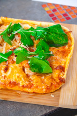 Pizza with basil, cheese and tomato in a wood table.