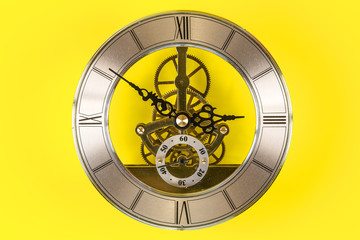 Fototapeta premium Vintage bronze clock isolated on a yellow background