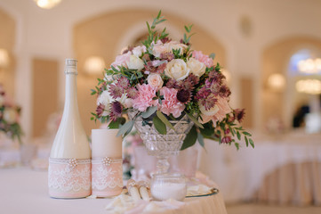 Beautifully decorated bouquet of roses with champagne and candles