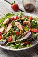 Strawberry Orange Honey Balsamic Salad on spring baby greens and spinach on an old barn wood table