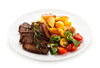 Steaks, baked potatoes and vegetable salad 