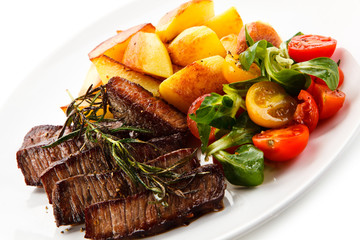 Steaks, baked potatoes and vegetable salad 