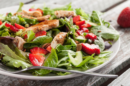 Strawberry Orange Honey Balsamic Salad on spring baby greens and spinach horizontal shot