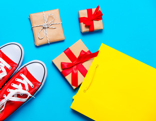 big red gumshoes, cool shopping bag and beautiful gifts on the wonderful blue background
