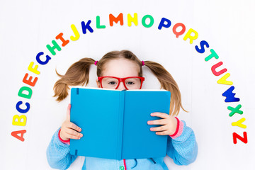 Child learning letters of alphabet and reading