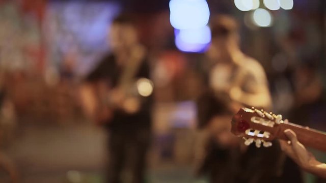 Street musicians with guitars playing for people.