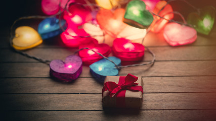 beautiful colorful heart shaped garland and cute gift lying on the wonderful brown wooden background