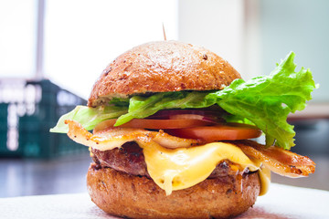Home made burger with cheese, tomato and bacon