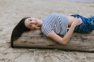 Stylish and fashionable girl in white hat posing on the summer beach.