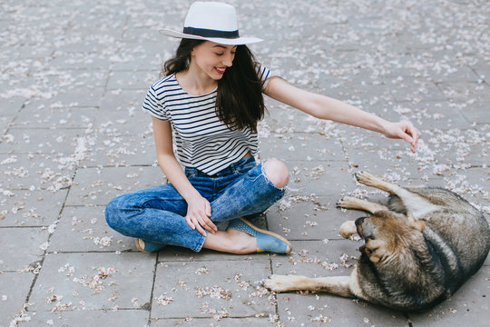 Girl playing with street dog.