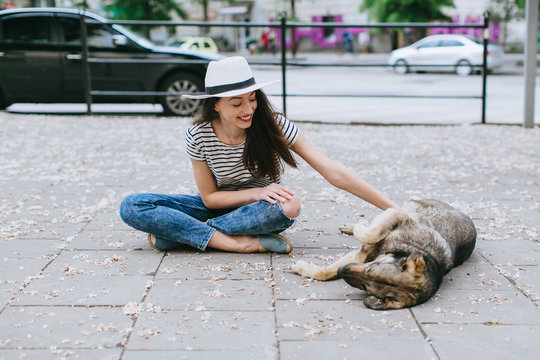 Girl playing with street dog.