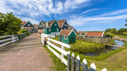 Dutch village scene with wooden houses and bridge over canal