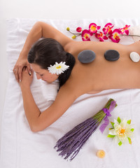Obraz na płótnie Canvas Young woman receiving hot stone massage
