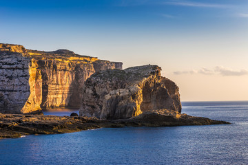 Gozo, Malta - The famous Fungus rock on the island of Gozo at Dwejra bay at sunset - obrazy, fototapety, plakaty