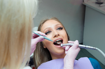 beautiful woman on the inspection of the teeth in dentistry
