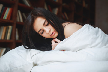 Obraz na płótnie Canvas sensual woman with dark hair lying on a bed