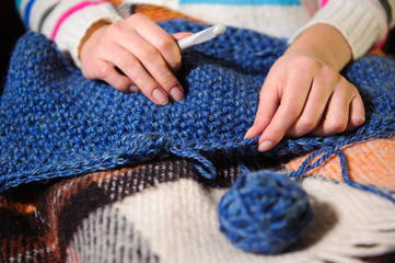 Close-up of woman hands knitting colorful wool yarn.