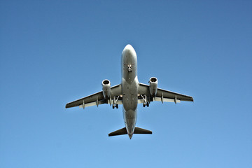 Fototapeta na wymiar Big Commercial aircraft with it silver body isolated alone against the blue sky
