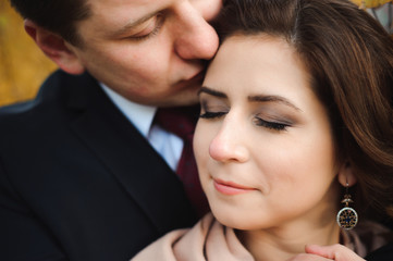 Couple walks in the park. Romantic embrace of newlyweds.