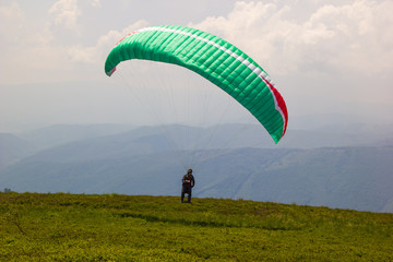 Sporty young man getting ready to fly paraglider