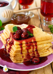 Stack of thin crepes with cherry topping