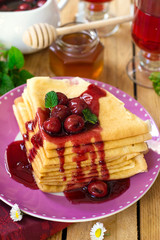 Stack of thin crepes with cherry topping