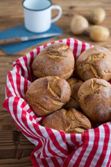 Kartoffeldinkelbrötchen mit Emailbecher im Hintergrund