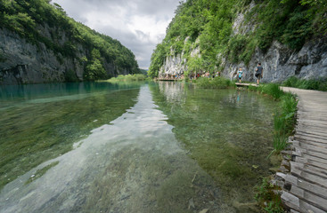 Tourists walk along the wooden boardwalks in one of Europe's most popular national parks, Plitvice Lakes National Park in Croatia.