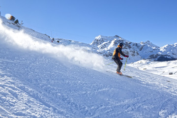 skier going down the mountain very fast in a sunny day