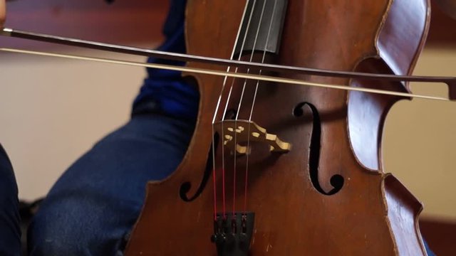 Teen violoncellist playing a cello