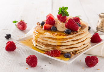 delicious pancakes on wooden table with fruits
