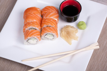 Philadelphia sushi roll with red fish on a white plate